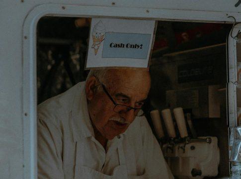 Woman counting a stack of dollar bills for a cash-only spending diet.