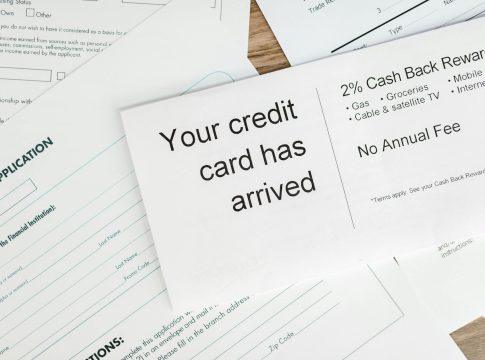 Credit card rewards strategy graphic showing stacked coins and cards.