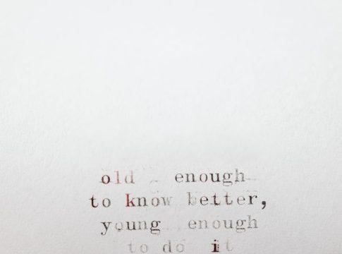 A person stands at a crossroads sign pointing to 