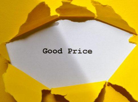 A house key rests on a stack of bills and documents, symbolizing hidden home costs.