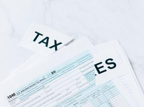 Woman looking thoughtfully at a laptop screen about a pay cut for balance.