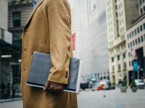 Woman looking thoughtfully at a laptop displaying financial charts.