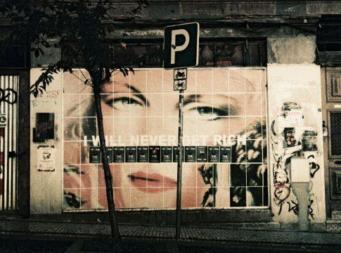 Man looking stressed at a desk covered in bills and paperwork.